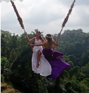 Two guests on the Bali jungle swing above the valley